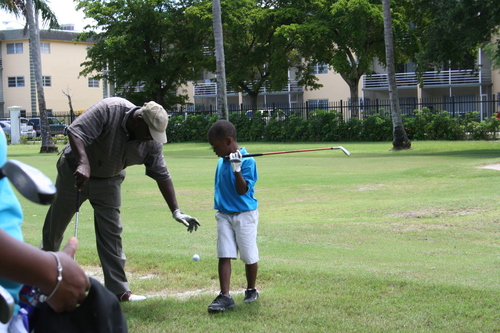 man-teaching-golf-to-a-boy