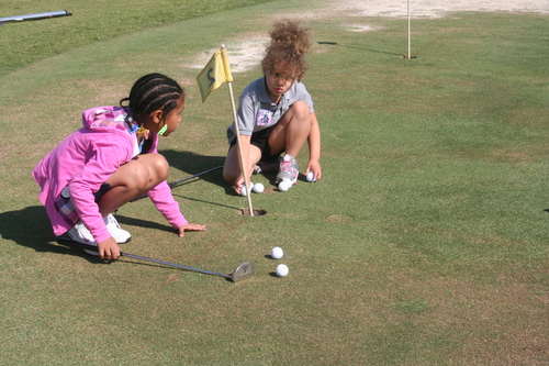 two-girls-playing-golf